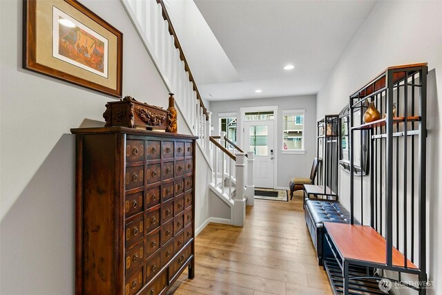 entrance foyer featuring baseboards, stairway, light wood finished floors, and recessed lighting