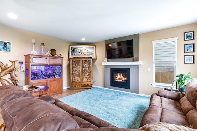 living area featuring recessed lighting, baseboards, and a glass covered fireplace