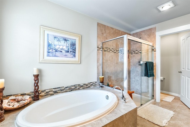 bathroom with a garden tub, a shower stall, and tile patterned flooring