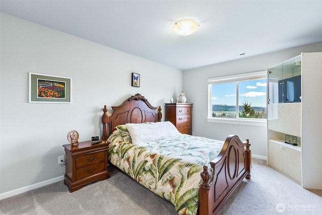 bedroom featuring baseboards, visible vents, and light carpet