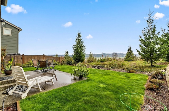 view of yard with a mountain view, fence, and a patio area