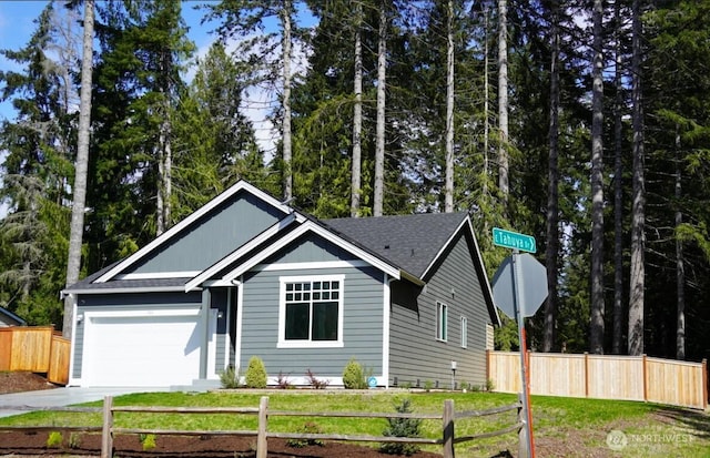 ranch-style home with concrete driveway, an attached garage, fence, and a front lawn