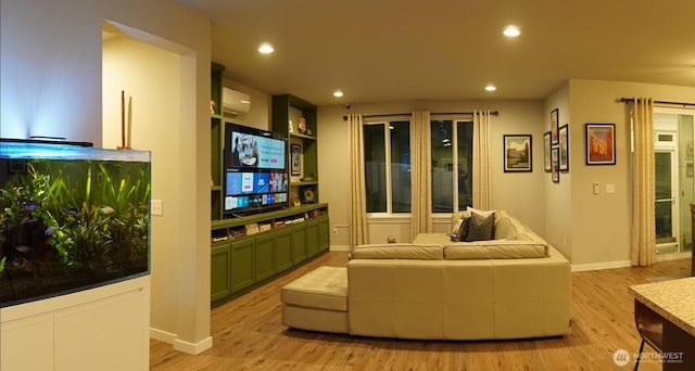 interior space featuring recessed lighting, baseboards, a wall unit AC, and light wood-style floors