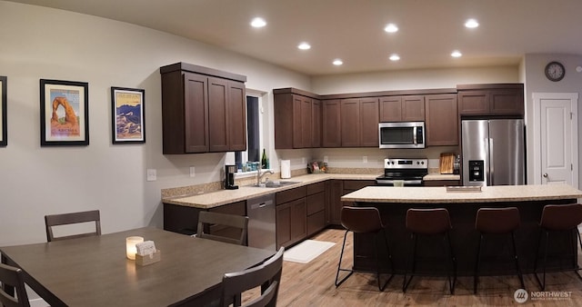 kitchen with a kitchen island, stainless steel appliances, dark brown cabinetry, and recessed lighting