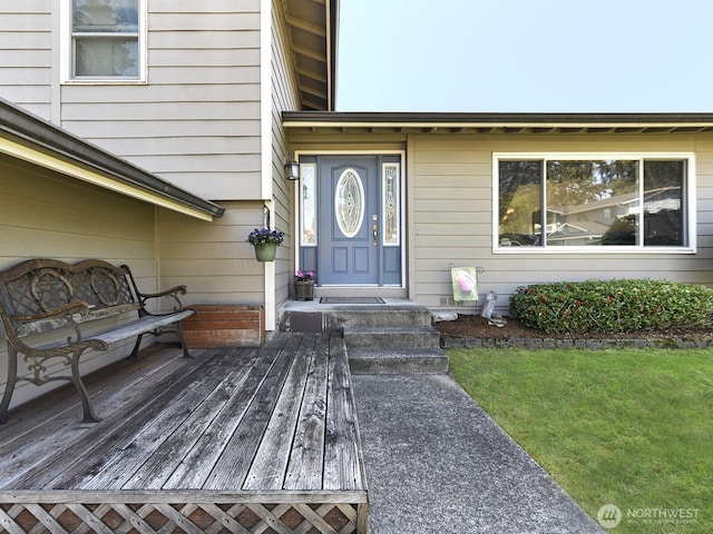 view of exterior entry with a lawn