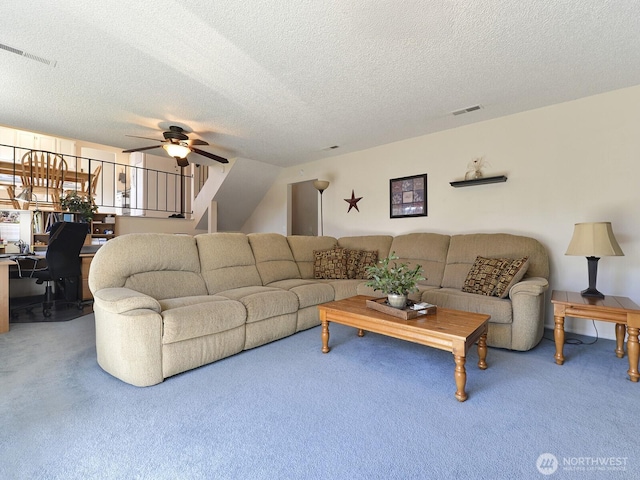 carpeted living area featuring visible vents, a textured ceiling, and ceiling fan