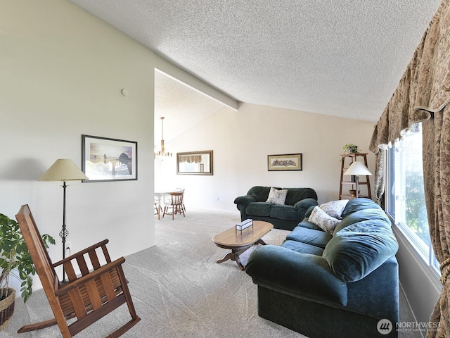 carpeted living room featuring lofted ceiling with beams, a textured ceiling, and a notable chandelier