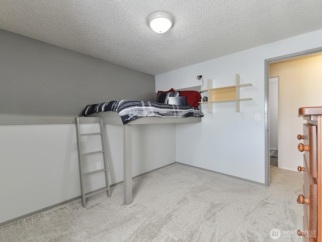 unfurnished bedroom with carpet floors, a textured ceiling, and baseboards