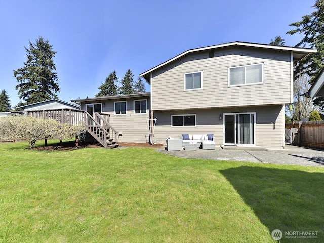 back of house with an outdoor living space, a patio area, a wooden deck, and a yard