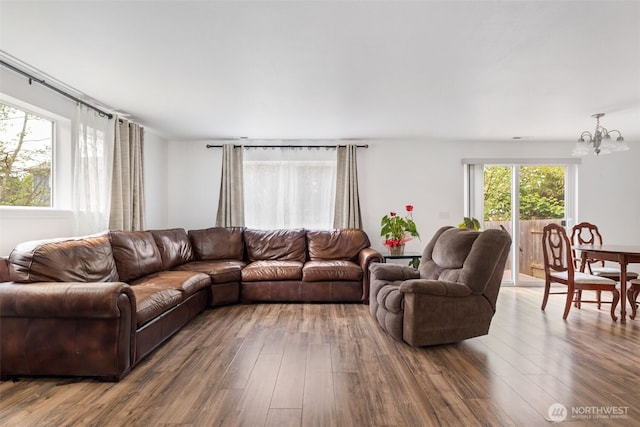 living room with an inviting chandelier and wood finished floors
