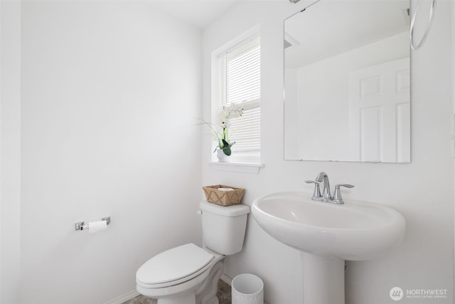 bathroom featuring baseboards, a sink, and toilet