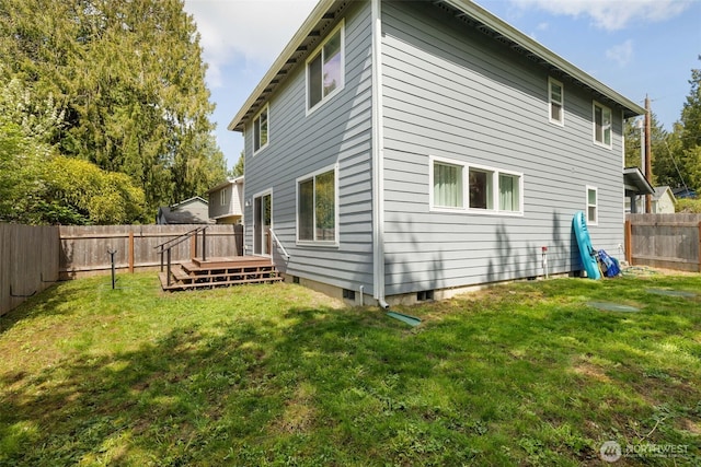 rear view of house with a yard, a deck, and a fenced backyard