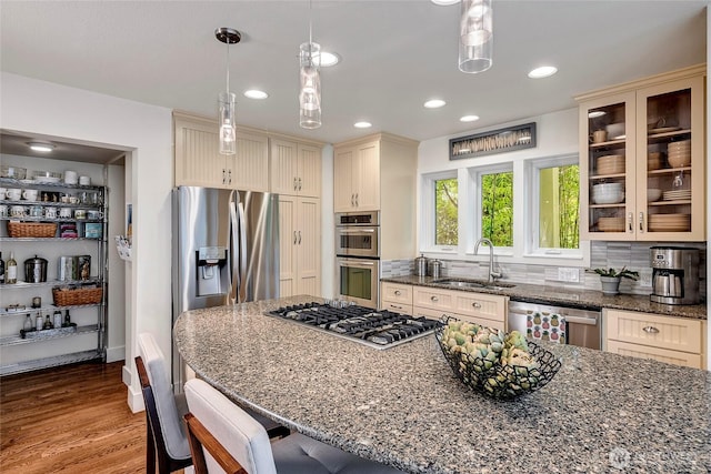 kitchen featuring a sink, glass insert cabinets, stainless steel appliances, and dark stone countertops