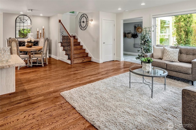living room with baseboards, stairs, wood finished floors, and a wealth of natural light