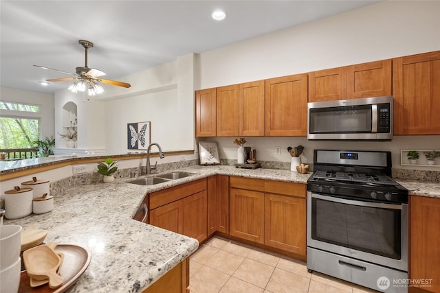 9229 122nd Ct NE Unit 13, Kirkland, WA 98033 - kitchen with brown cabinets, light stone countertops, appliances with stainless steel finishes, a sink, and light tile patterned floors