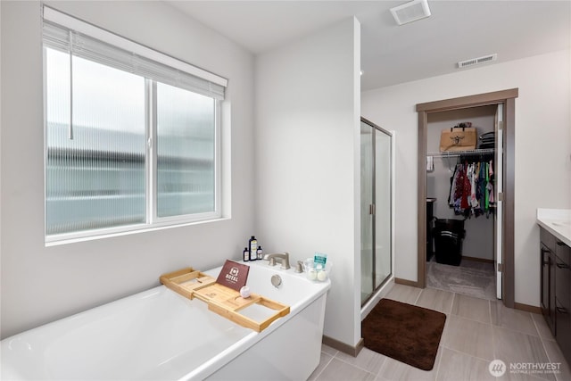 5198 Sophie St, Bremerton, WA 98312 - full bathroom with visible vents, vanity, a freestanding tub, a walk in closet, and a stall shower