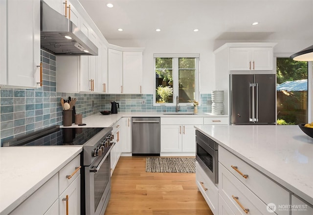 10419 41st Ave SW Unit A & B, Seattle, WA 98146 - kitchen with premium appliances, under cabinet range hood, recessed lighting, healthy amount of natural light, and white cabinetry