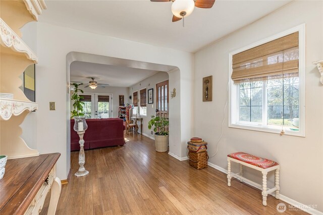 corridor with baseboards and wood finished floors