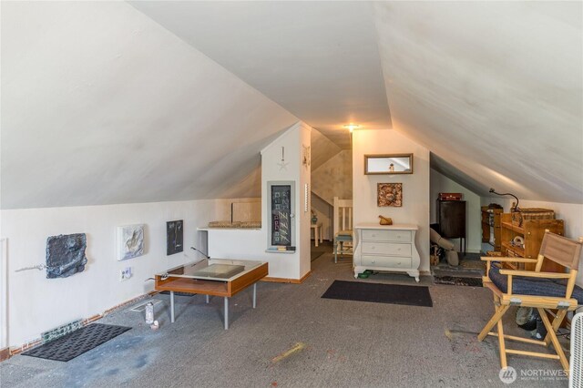 interior space with carpet and vaulted ceiling