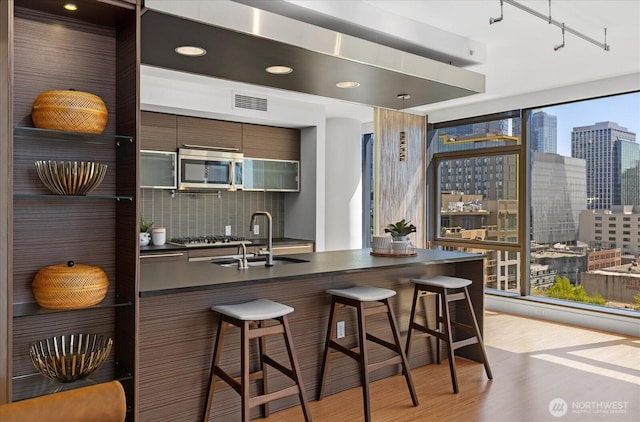 820 Blanchard St Unit 1507, Seattle, WA 98121 - kitchen with dark countertops, modern cabinets, a sink, stainless steel appliances, and light wood-style flooring