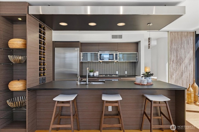 820 Blanchard St Unit 1507, Seattle, WA 98121 - kitchen featuring backsplash, visible vents, dark countertops, appliances with stainless steel finishes, and a sink