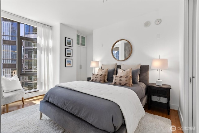 820 Blanchard St Unit 1507, Seattle, WA 98121 - bedroom featuring multiple windows and wood finished floors