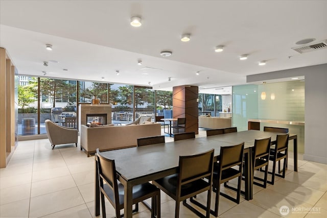 820 Blanchard St Unit 1507, Seattle, WA 98121 - dining area featuring a glass covered fireplace, floor to ceiling windows, light tile patterned flooring, and visible vents