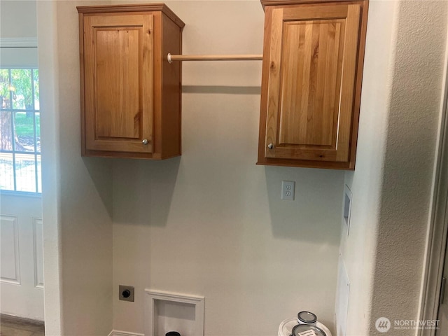 laundry room featuring electric dryer hookup and cabinet space