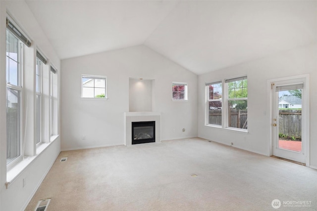 823 Landing Way, Centralia, WA 98531 - unfurnished living room featuring a glass covered fireplace, carpet, vaulted ceiling, and visible vents