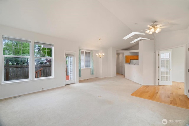 823 Landing Way, Centralia, WA 98531 - unfurnished living room with plenty of natural light, ceiling fan with notable chandelier, lofted ceiling, and light colored carpet
