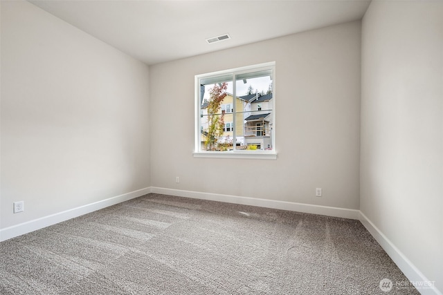 spare room with carpet floors, baseboards, and visible vents