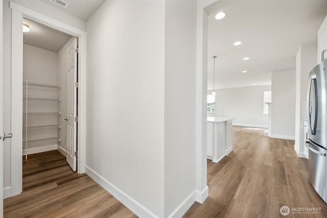 corridor featuring recessed lighting, baseboards, light wood-type flooring, and visible vents