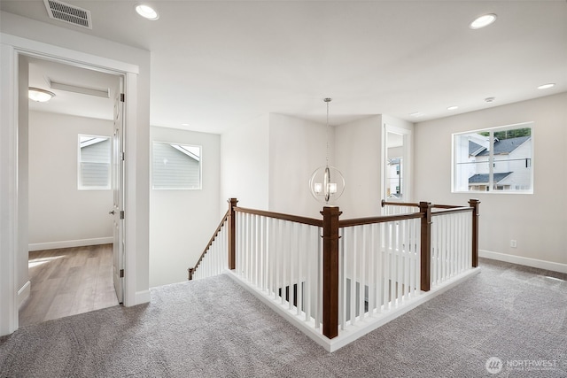 corridor with carpet, recessed lighting, baseboards, an upstairs landing, and visible vents