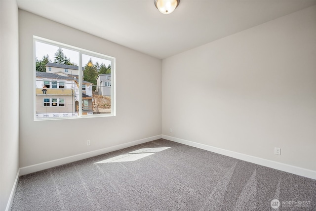 empty room featuring baseboards and carpet floors