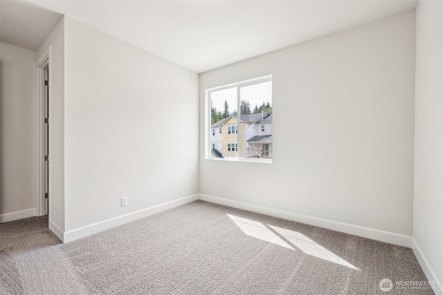 unfurnished room with carpet floors and baseboards