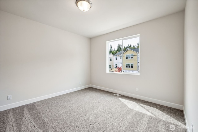 empty room featuring carpet floors, baseboards, and visible vents