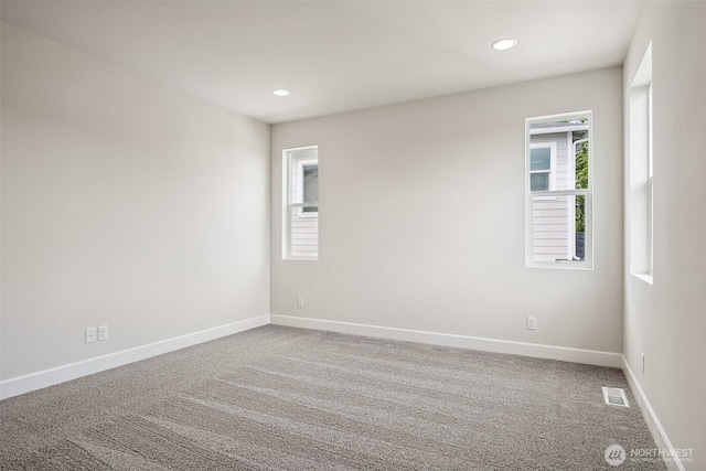 empty room with baseboards, carpet, recessed lighting, and visible vents