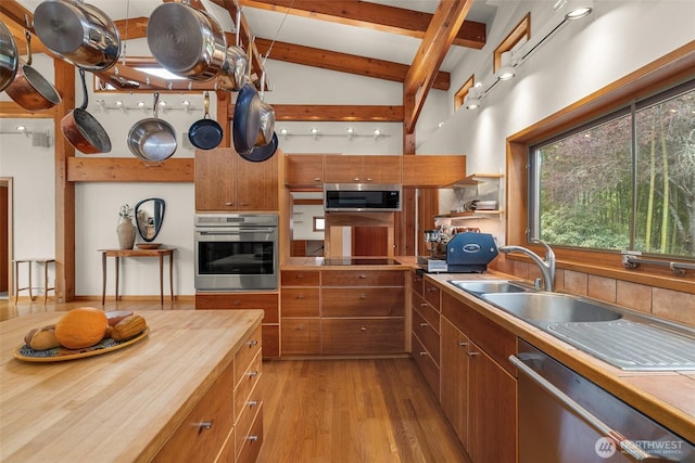 7606 Brown Rd SW, Olympia, WA 98512 - kitchen featuring appliances with stainless steel finishes, light wood-style floors, brown cabinetry, beam ceiling, and open shelves