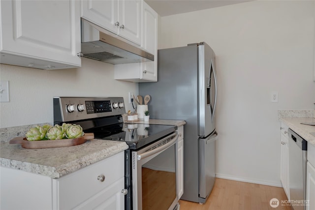 1156 Alki Ave SW Unit 105, Seattle, WA 98116 - kitchen with appliances with stainless steel finishes, white cabinetry, light countertops, under cabinet range hood, and light wood-style flooring