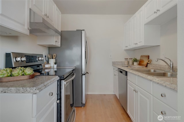 1156 Alki Ave SW Unit 105, Seattle, WA 98116 - kitchen with a sink, white cabinets, under cabinet range hood, light wood-style floors, and stainless steel appliances
