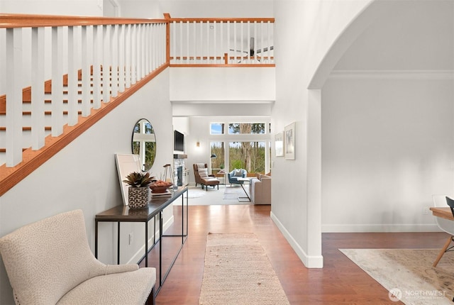 3679 Silver Oak Ct, Bellingham, WA 98226 - foyer featuring crown molding, arched walkways, baseboards, wood finished floors, and a towering ceiling
