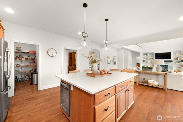 3679 Silver Oak Ct, Bellingham, WA 98226 - kitchen with freestanding refrigerator, wine cooler, wood finished floors, a center island, and light countertops