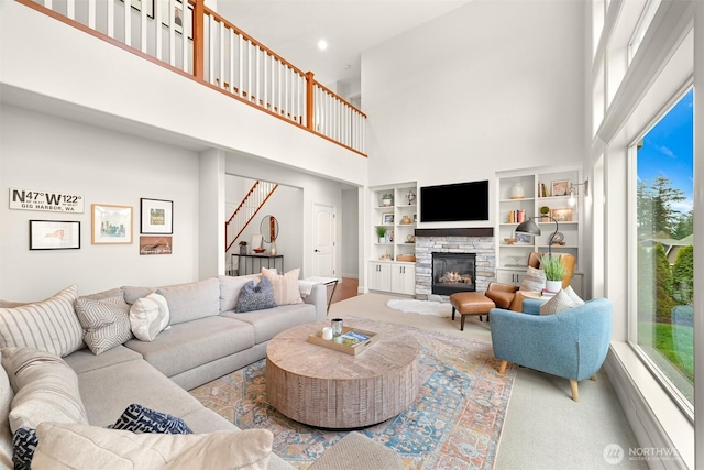 3679 Silver Oak Ct, Bellingham, WA 98226 - carpeted living area with a stone fireplace, stairs, a towering ceiling, and built in shelves