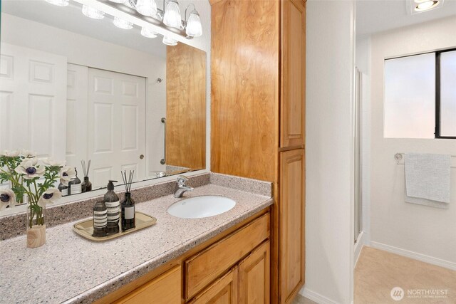 full bath with baseboards, a shower with door, and vanity