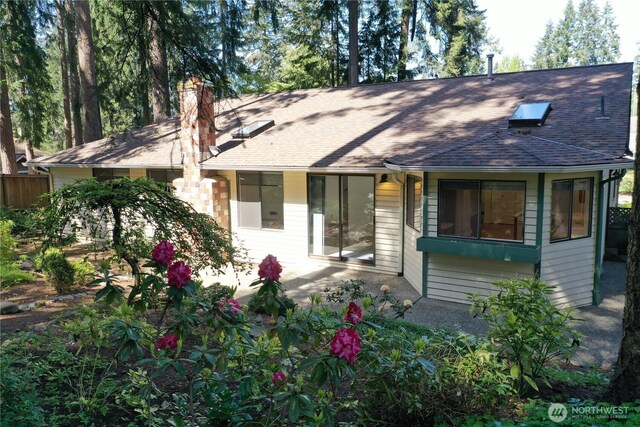 view of front of house featuring a shingled roof and a chimney
