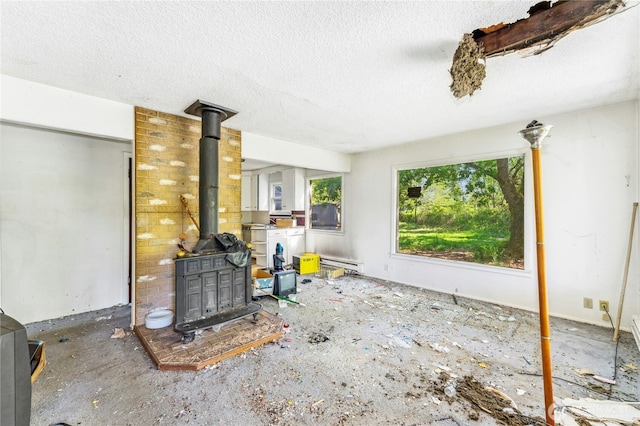 99 Sumner Ave, Sumner, WA 98390 - unfurnished living room featuring baseboard heating, a wood stove, and a textured ceiling