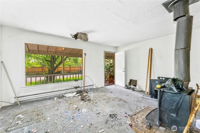 99 Sumner Ave, Sumner, WA 98390 - living room featuring baseboard heating, a wood stove, and a textured ceiling