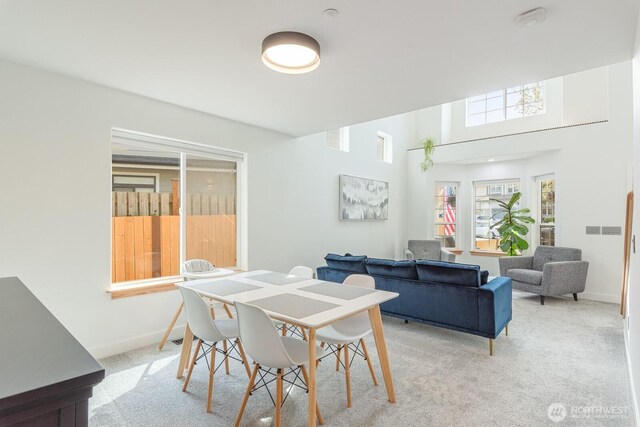 dining area featuring baseboards and light carpet