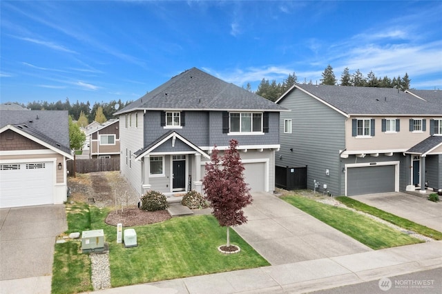traditional home with driveway, a front yard, fence, an attached garage, and a shingled roof