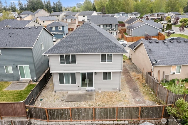 back of house featuring a patio, a residential view, a shingled roof, and entry steps